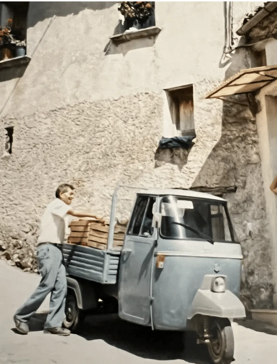 Historic photo: man with an Ape three-wheeler in an Italian alley