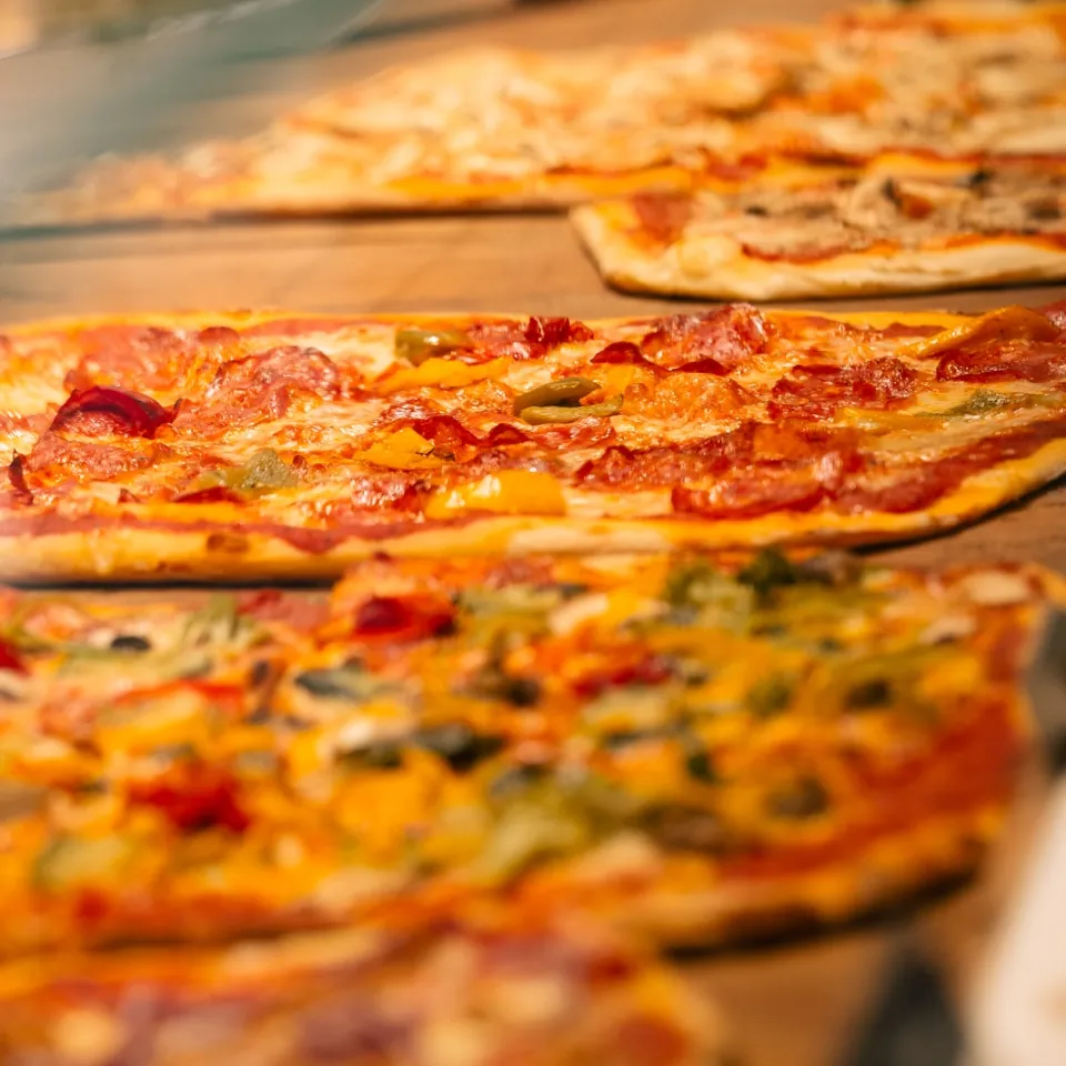 Mehrere Pizzen aus dem Steinofen nebeneinander